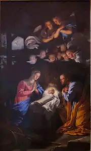 Dans une étable, Marie, les mains jointes, et Joseph, les mains croisées, regardent l'enfant Jésus emmailloté dans son berceau, sous le regard de deux anges et de huit angelots